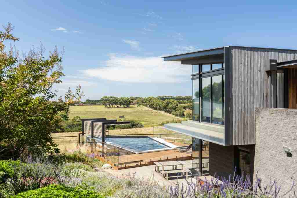 Steps leading down to a beautifully designed Laguna landscape and pool that resembles a diamond. The pool has decking surround it.